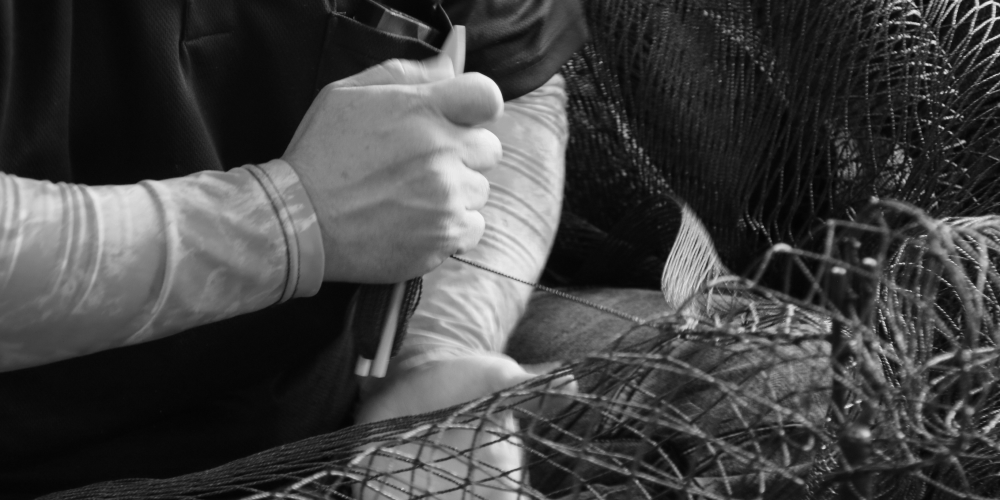 製網道具を使用して手作業で製網している様子